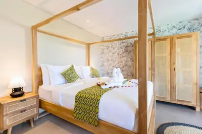 a bedroom with a large bed with a wooden frame at Garbera 2 BR Private Pool Villa in Canggu