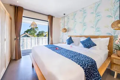 a bedroom with a large bed with blue and white pillows at Garbera 2 BR Private Pool Villa in Canggu