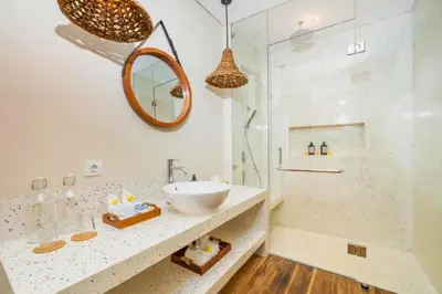 a bathroom with a sink and a mirror and a shower at Garbera 2 BR Private Pool Villa in Canggu