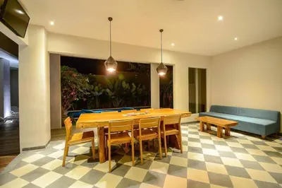 a dining room with a table and chairs and a couch at Cosy 1 Bd Pvt Apartment with shared kitchen and pool in Seminyak