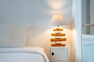 a lamp on a night stand next to a bed at Cosy 1 Bd Pvt Apartment with shared kitchen and pool in Seminyak
