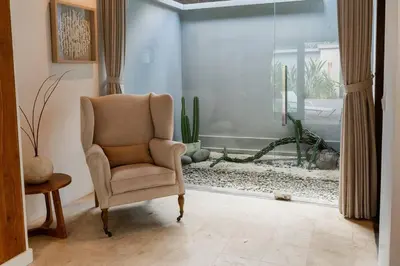 a living room with a chair and an aquarium at Ocean Breeze Villa -4BR villa in Canggu in Canggu