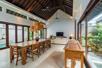 a dining room with a large wooden table and chairs at Ocean Breeze Villa -4BR villa in Canggu in Canggu