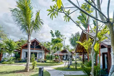 a resort with palm trees in front of it at One BR Bungalow Cozy Place in Canggu