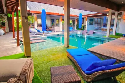 a swimming pool with lounge chairs in a house at Kamila Aranne 3 BR Private Pool Villa in Jimbaran