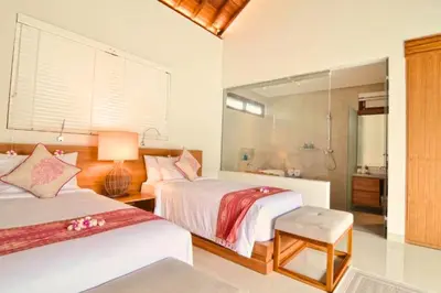 a hotel room with two beds and a bathroom at Kamila Aranne 3 BR Private Pool Villa in Jimbaran