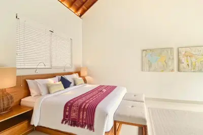a bedroom with a large bed and a table at Kamila Aranne 3 BR Private Pool Villa in Jimbaran