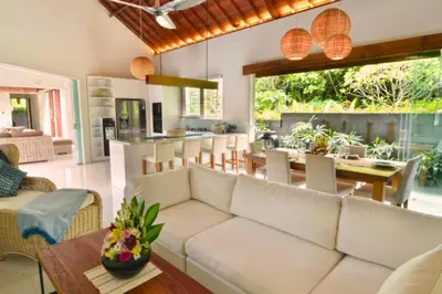 a living room with a white couch and a table at Kamila Aranne 3 BR Private Pool Villa in Jimbaran