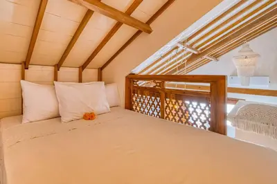 a bed in the corner of a room at New Listing 1 BD Vintage Charm in Central Berawa in Canggu