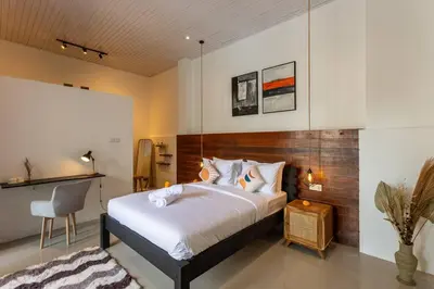 a bedroom with a large bed and a chair at Comfy 3bd Family Villa with Private Pool in Central Location in Kerobokan
