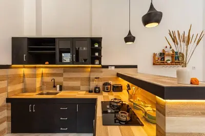 a kitchen with black cabinets and a counter top at Comfy 3bd Family Villa with Private Pool in Central Location in Kerobokan