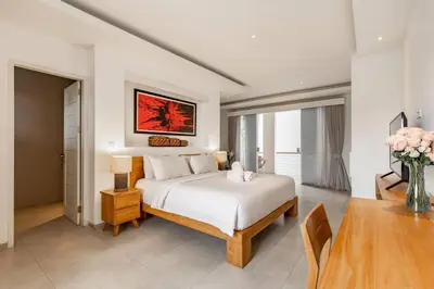 a white bedroom with a bed and a table at Stylish 1 Bd Pvt Apartment w shared kitchen and pool in Seminyak