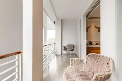 a white hallway with two chairs and a table at Stylish 1 Bd Pvt Apartment w shared kitchen and pool in Seminyak