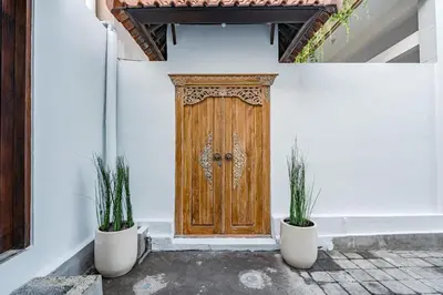 a wooden door with two potted plants in front of it at Villa Crystal 9b in Seminyak