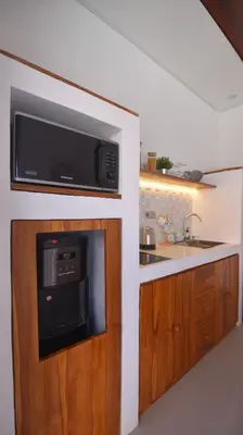 a kitchen with a microwave and a sink at Queen Villa Seminyak in Seminyak