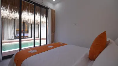 a bedroom with a bed and a large window at Queen Villa Seminyak in Seminyak