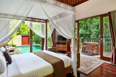 a bedroom with a bed and a balcony with a pool at Ari Ayra 1 BR Private Pool Villa in Jimbaran
