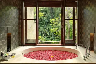 a bath tub filled with red rocks in front of a window at Ari Ayra 1 BR Private Pool Villa in Jimbaran