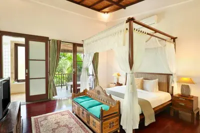 a bedroom with a canopy bed and a television at Dean 2 BR Private Pool Villa in Jimbaran