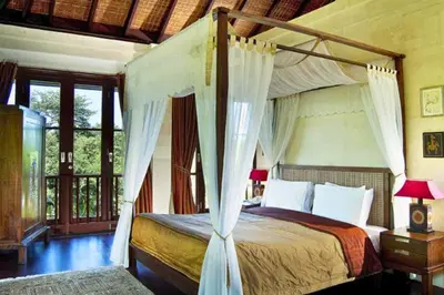 a bedroom with a bed with a canopy at Azarina 3 BR Private Pool Villa in Jimbaran