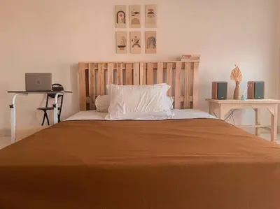 a bedroom with a large bed with a wooden headboard at Conscious House near Kuta and Seminyak in Legian
