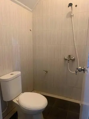 a bathroom with a toilet and a shower at Conscious House near Kuta and Seminyak in Legian