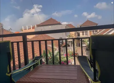 a balcony with chairs and a view of a building at Conscious House near Kuta and Seminyak in Legian