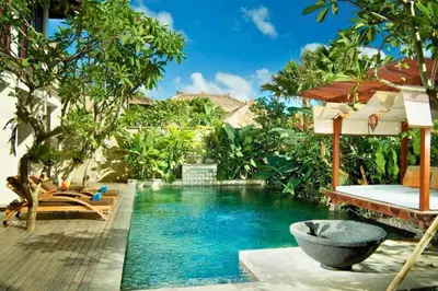 a pool at a resort with a bed and an umbrella at Dendalion 4 BR Private Pool Villa in Jimbaran