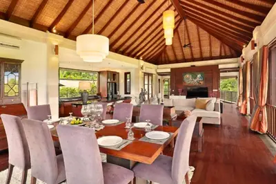 a dining room and living room with a table and chairs at Dendalion 4 BR Private Pool Villa in Jimbaran
