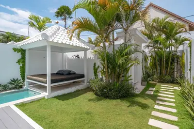 a bed in a gazebo next to a pool at Sea Breeze Retreat Modern 3BR Villas in Canggu in Canggu