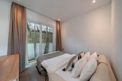 a bedroom with a bed and a large window at Sea Breeze Retreat Modern 3BR Villas in Canggu in Canggu