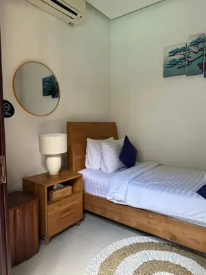 a bedroom with two beds and a lamp and a mirror at The Golden Serendipity Villa Seminyak in Seminyak