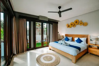 a bedroom with a large bed and a balcony at The Golden Serendipity Villa Seminyak in Seminyak