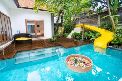 a pool with a slide in a house at Sweet 3 BR Private Pool Villa Garden View in Kerobokan