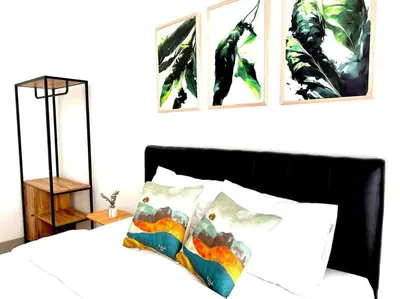 a bedroom with a bed with two pictures on the wall at Cosy 3 bedrooms at budget price @ Jimbaran in Jimbaran