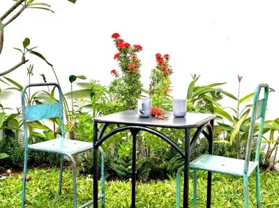 a table and two chairs with flowers on it at Cosy 3 bedrooms at budget price @ Jimbaran in Jimbaran