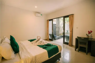 a bedroom with a bed and a sliding glass door at Taman Bali Villa Kerobokan in Kerobokan