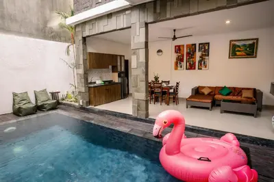 a large pink inflatable swan in a swimming pool at Taman Bali Villa Kerobokan in Kerobokan