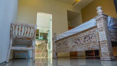 a bed and a chair in a room at Dirga's House Sanur View by EPS in Sanur