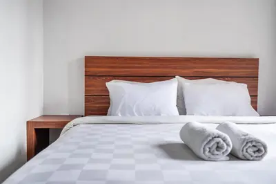 a bedroom with a bed with towels on it at Dukuh Segara Guest House in Legian