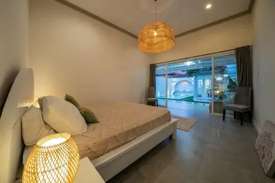 a bedroom with a bed and a living room at Lovely 3 BR villa with private pool in Canggu