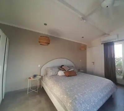 a bedroom with a large bed with a blue comforter at Lovely 3 BR villa with private pool in Canggu