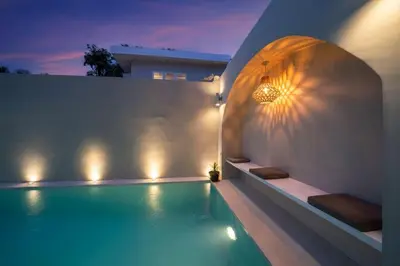 a swimming pool with lights on the side of a house at Lovely 3 BR villa with private pool in Canggu