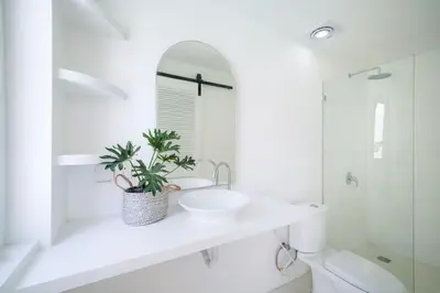 a bathroom with a sink and a toilet and a mirror at Lovely 3 BR villa with private pool in Canggu