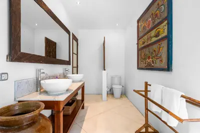 a bathroom with two sinks and a mirror at Sahaja Villa by Betterplace in Canggu