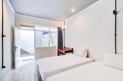 a hotel room with two beds and a window at Collection O at Jalan Padma near Legian Beach in Legian