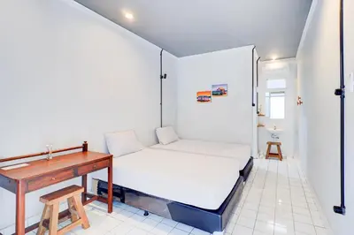 a small bedroom with a bed and a desk at Collection O at Jalan Padma near Legian Beach in Legian
