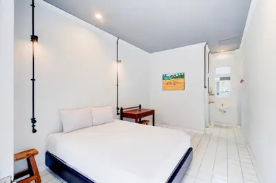 a bedroom with a white bed in a room at Collection O at Jalan Padma near Legian Beach in Legian