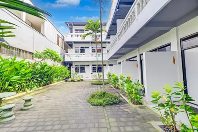 a courtyard of a building with trees and plants at Collection O at Jalan Padma near Legian Beach in Legian