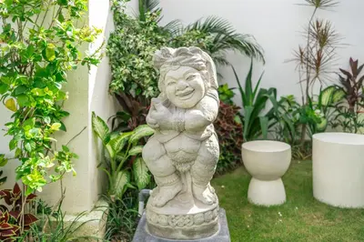 a statue of a woman standing in a garden at Aleksa - Villa with Rooftop&Rice Field View in Canggu